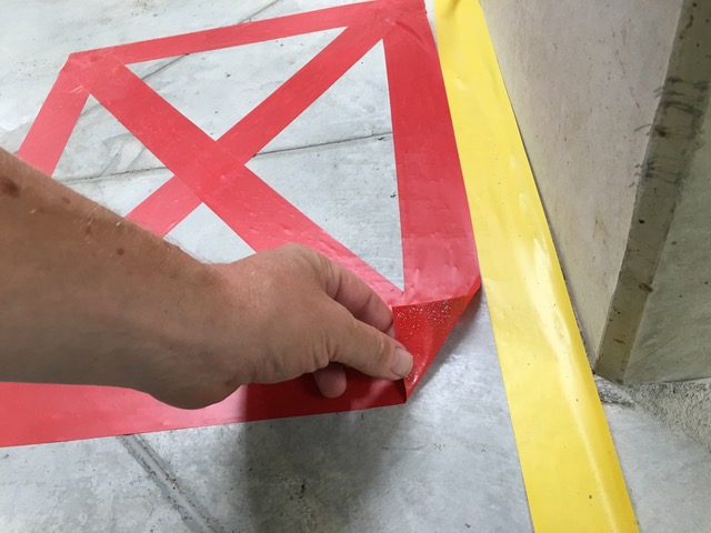 Detail ručního odstraňování červené pásky